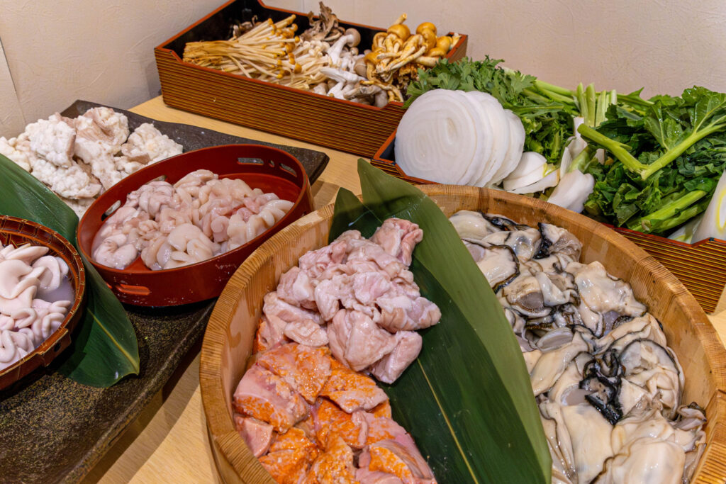 相模湖の静寂、西八王子の熱。仲間と囲む「痛風鍋」で締める、最高の休日。 皿に美しく盛られた新鮮な白子、あん肝、牡蠣などの痛風鍋の具材。