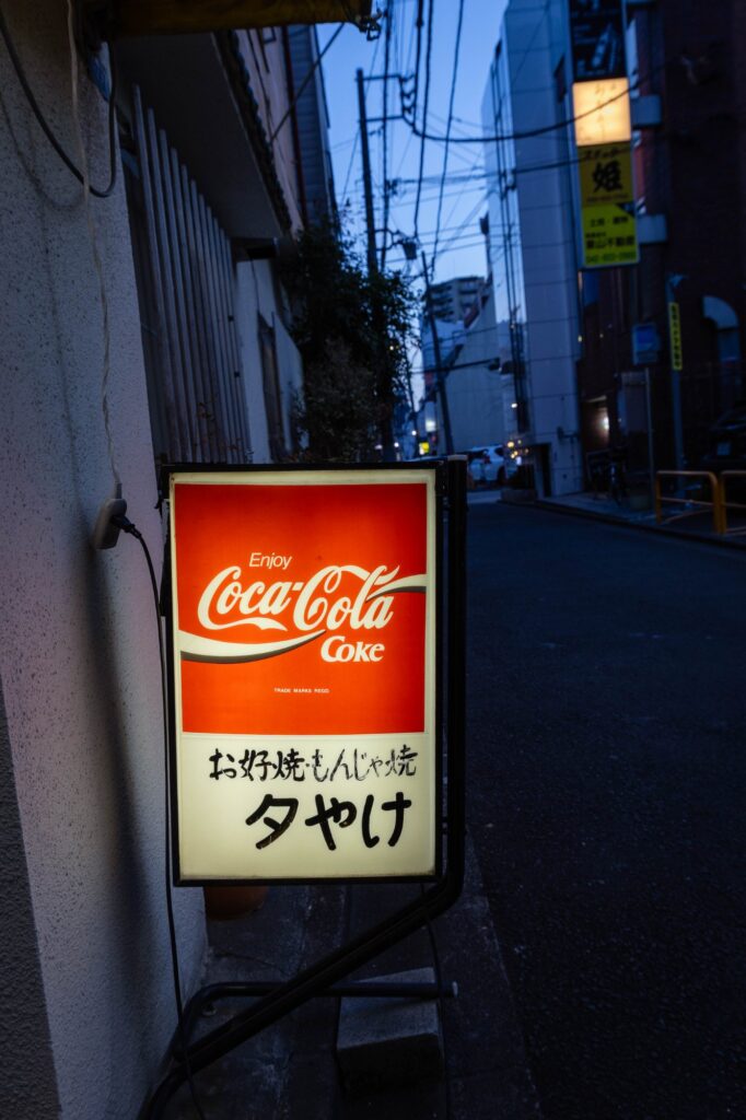 黄色い看板が灯る夜。八王子「夕やけ」で見つけた、昭和の温もり。 hachioji narrow alley with cocacola sign at dusk