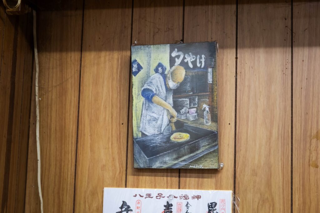 黄色い看板が灯る夜。八王子「夕やけ」で見つけた、昭和の温もり。 hachioji yuyake wall painting of chef cooking okonomiyaki