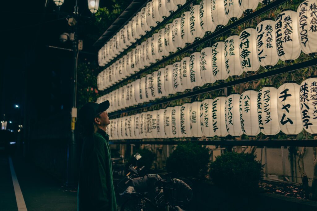 子安神社の境内に並ぶ提灯を見上げる参拝者