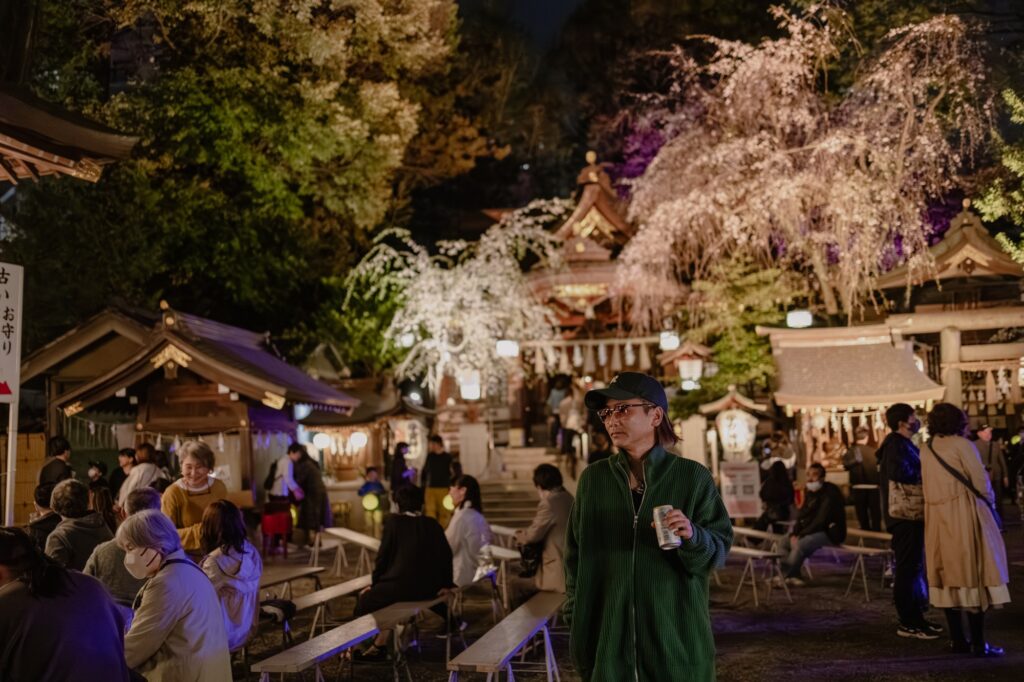 ライトアップされた桜の下で佇む男性